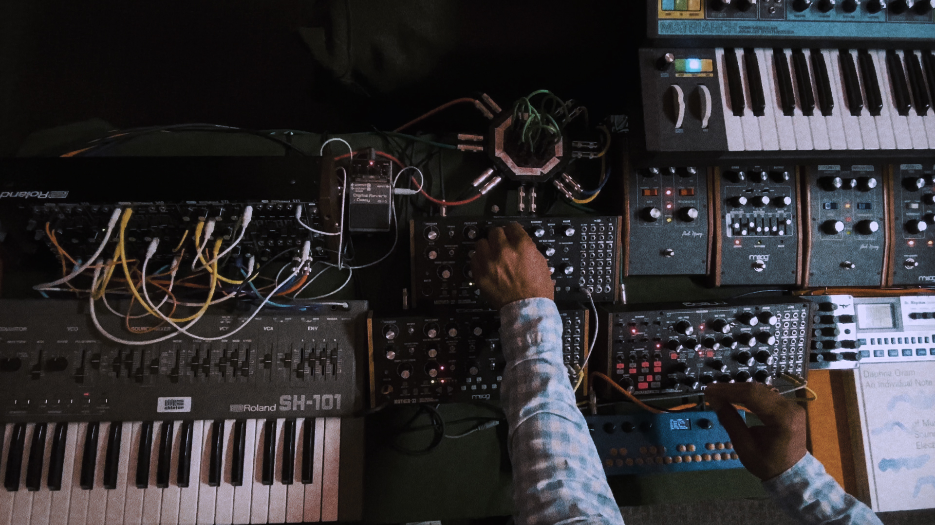 Professor King Britt's hands adjusting sound levels on an analog Moog synthesizer 